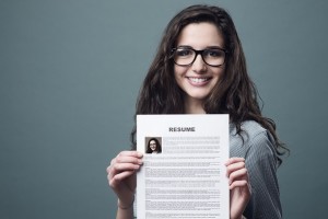 Young smiling cheerful woman holding her resume